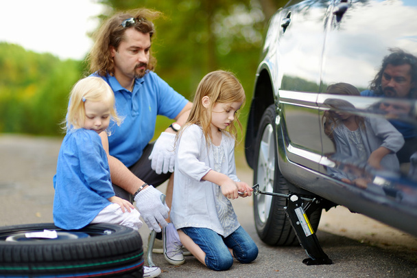 Little girl helping father with car - Foto, Imagen