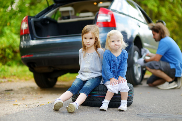 Little sisters sitting on tire - Foto, Imagen