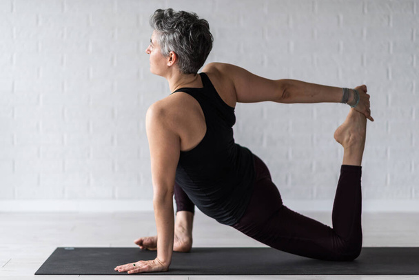 volwassen vrouw doen yoga - Foto, afbeelding