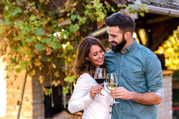 молода пара п'є вино в винограднику
  - Фото, зображення