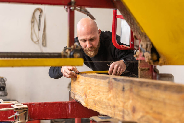 Professionele timmerman snijden enorme hout tot een kleine stukken, schrijnwerk concept - Foto, afbeelding