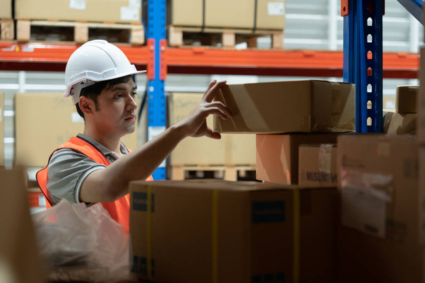 Warehouse worker pick box goods in inventory and check stock product. Transport logistic business ship delivery to customer. stock card, bill of material, inspection, storehouse, storage, factory - Foto, afbeelding