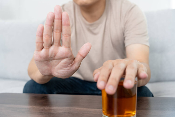 man refuses say no and avoid to drink an alcohol whiskey , stopping hand sign male, alcoholism treatment, alcohol addiction, quit booze, Stop Drinking Alcohol. Refuse Glass liquor, unhealthy, reject - Photo, Image