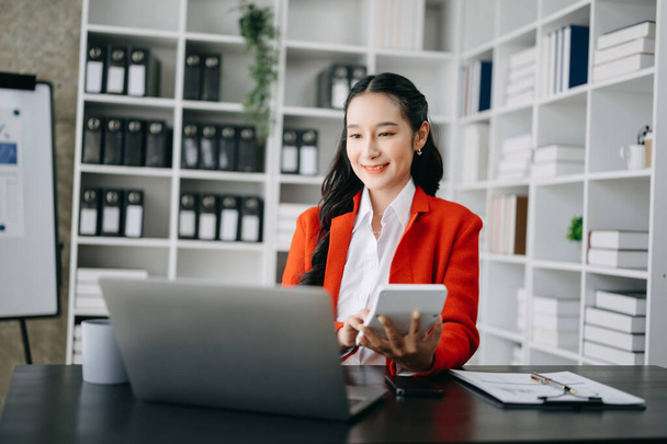 Woman freelancer is working her job on  laptop and calculator, Doing accounting analysis report real estate investment data, Financial at modern office - 写真・画像