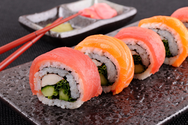 Rollo de sushi de salmón y atún con palillos
 - Foto, Imagen
