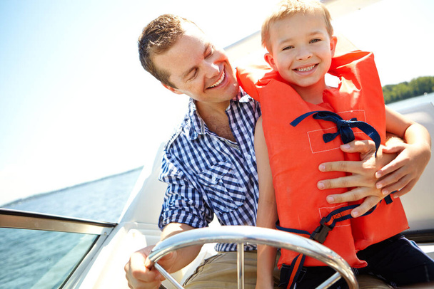 Zwei Jungen und ein Boot. Junger Vater und sein Sohn fahren gemeinsam im Schnellboot auf einem See - Foto, Bild