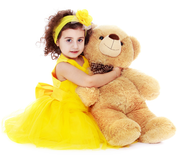 Fashionable dark-haired little girl hugging a bear - Foto, Bild