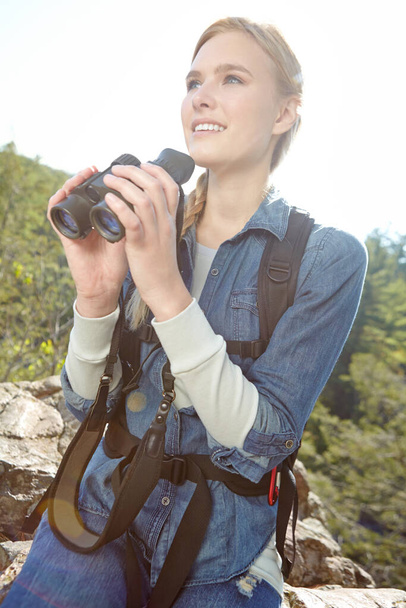 I think Ive spotted something...A beautiful young woman holding her binoculars while atop the mountainside - Photo, Image