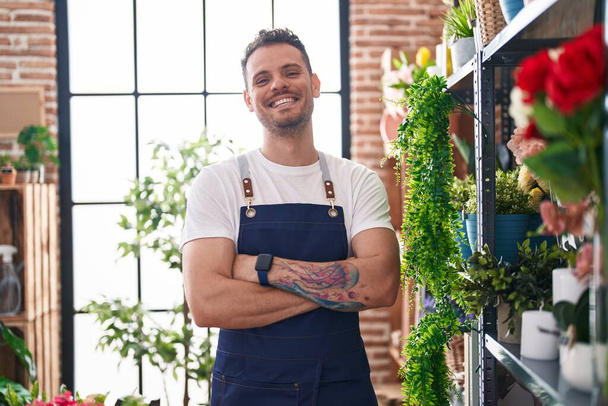Young hispanic man florist smiling confident standing with arms crossed gesture at florist - Photo, image