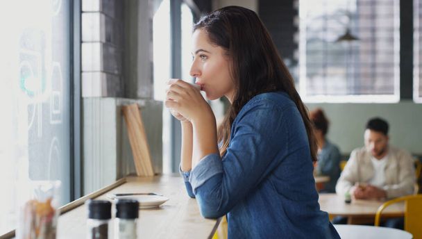 Ничто не возбуждает ум лучше, чем горячая чашка чая. привлекательная молодая женщина пьет кофе в кафе - Фото, изображение