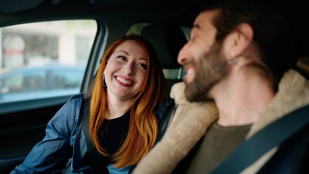 Hombre y mujer pareja sonriendo confiado coche de conducción en la calle - Foto, imagen