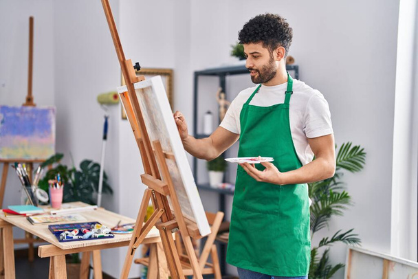 młody arabski człowiek artysta uśmiechnięty pewny siebie rysunek w studio sztuki - Zdjęcie, obraz