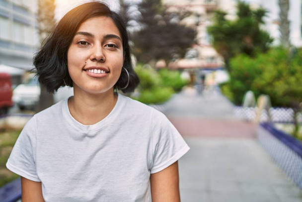 Jeune femme latine souriante confiante debout dans la rue - Photo, image