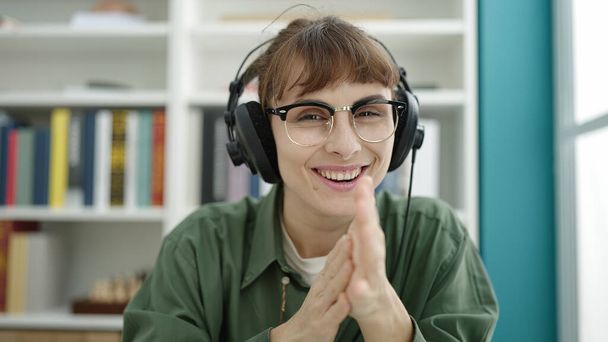 Junge Kaukasierin mit Kopfhörer am Computer an der Universität - Foto, Bild