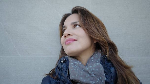 Молода красива іспаномовна жінка посміхається впевнено дивиться в небо над ізольованим білим тлом
 - Фото, зображення