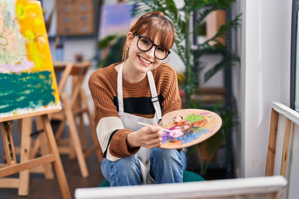 Young woman artist smiling confident drawing at art studio - 写真・画像