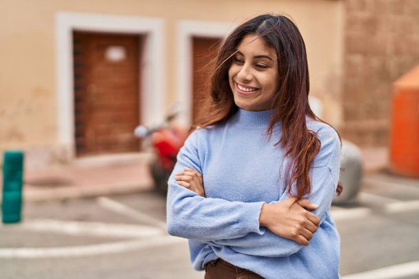 Young hispanic woman smiling confident standing with arms crossed gesture at street - Photo, image