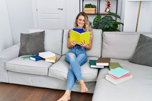 Young woman sitting on sofa studying at home - Photo, Image