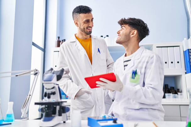 Два человека ученые используют тачпад, работающие в лаборатории - Фото, изображение