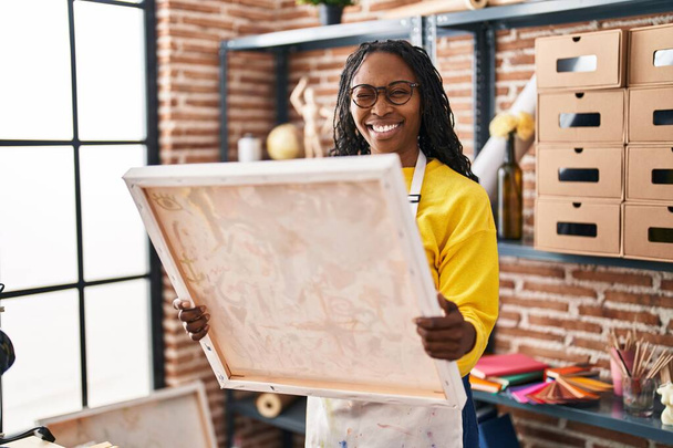 Mujer africana mirando a pintor lienzo guiño mirando a la cámara con expresión sexy, cara alegre y feliz.  - Foto, imagen