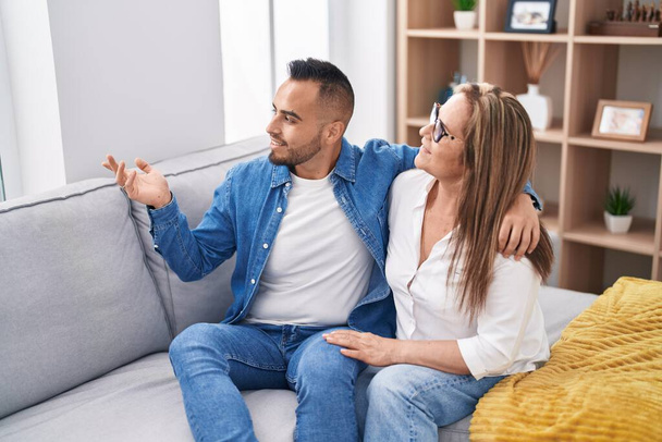 Mann und Frau Mutter und Sohn sitzen auf Sofa und sprechen zu Hause - Foto, Bild