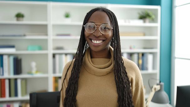 Afrykanka uśmiechnięta pewnie na uniwersytecie w bibliotece - Zdjęcie, obraz