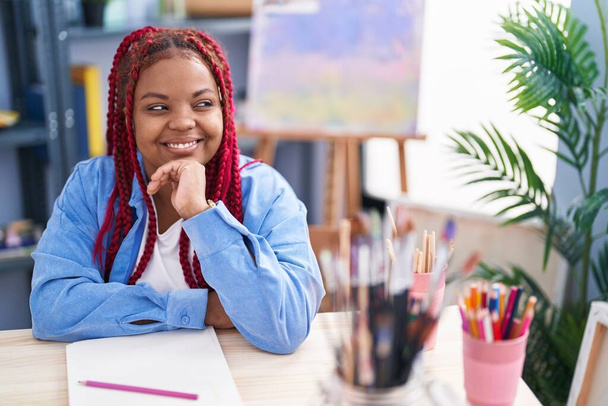 Afrikkalainen amerikkalainen nainen taiteilija hymyilee luottavainen piirustus kannettavan klo art studio - Valokuva, kuva