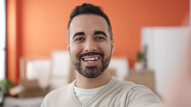 Young hispanic man having video call standing at new home - Foto, immagini