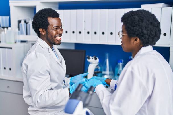 African american man and woman scientists working together speaking at laboratory - Photo, Image