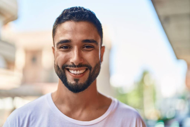 Young arab man smiling confident standing at street - Fotoğraf, Görsel