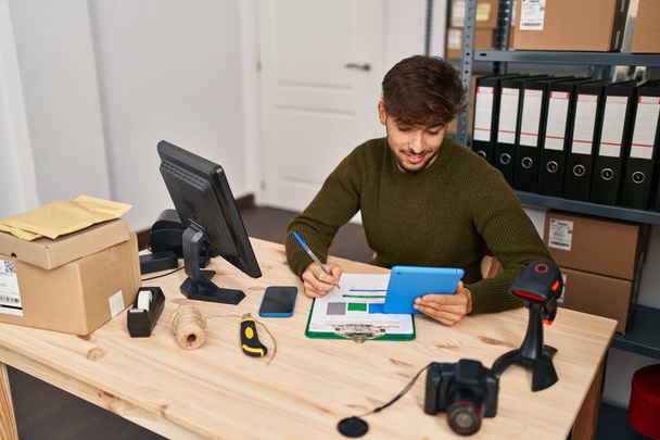 młody arabski człowiek e-commerce pracownik biznesu pisanie na dokumencie za pomocą touchpad w biurze - Zdjęcie, obraz