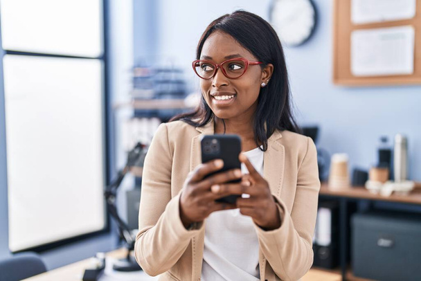 Młoda afrykańska kobieta biznes pracownik za pomocą smartfona w biurze - Zdjęcie, obraz