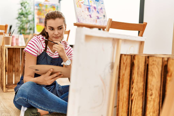 Mujer joven buscando dibujar en el estudio de arte - Foto, imagen