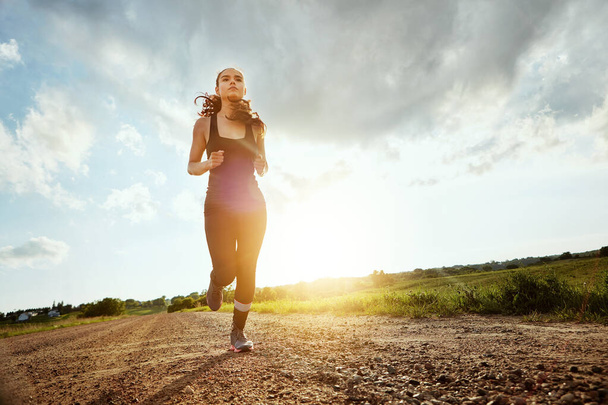 Good things come to those who sweat. a fit young woman out for a run on a beautiful day - Photo, Image