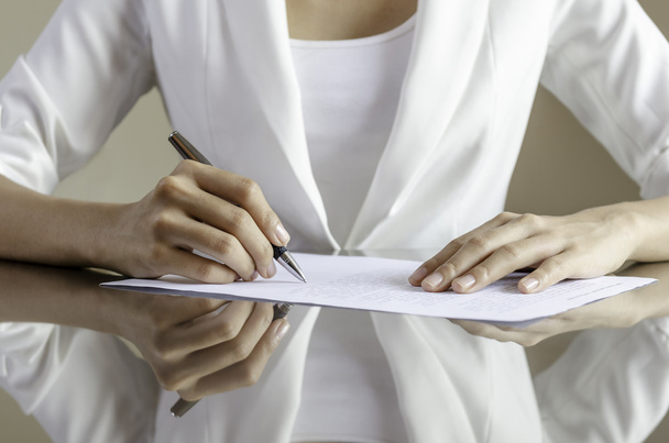 A woman signing a contract - Φωτογραφία, εικόνα