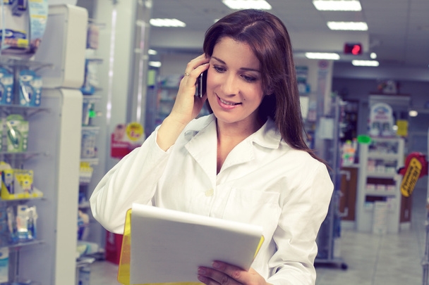 Felice farmacista femminile al telefono in farmacia
 - Foto, immagini