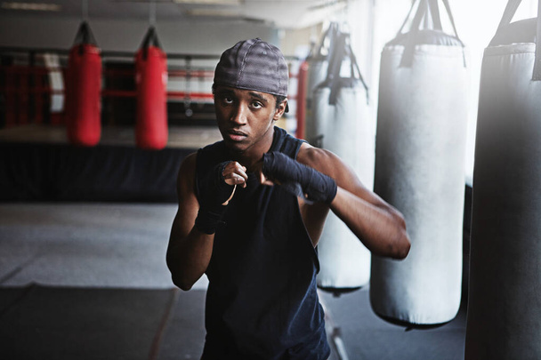 Give your best shot. a kick-boxer training in a gym - Zdjęcie, obraz