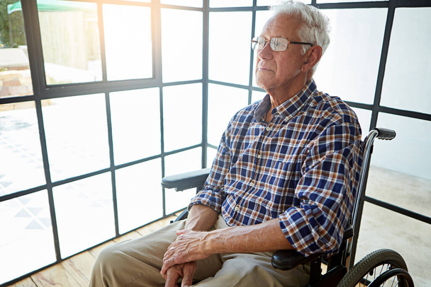 The senior years. a senior man sitting in his wheelchair in the retirement home - Fotó, kép