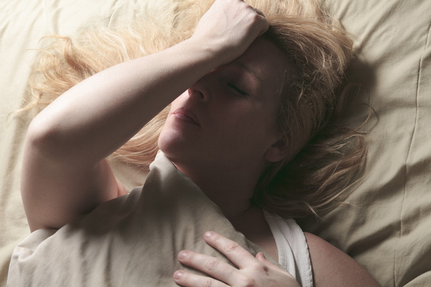 A woman feel sick lying down on bed - Foto, Imagem