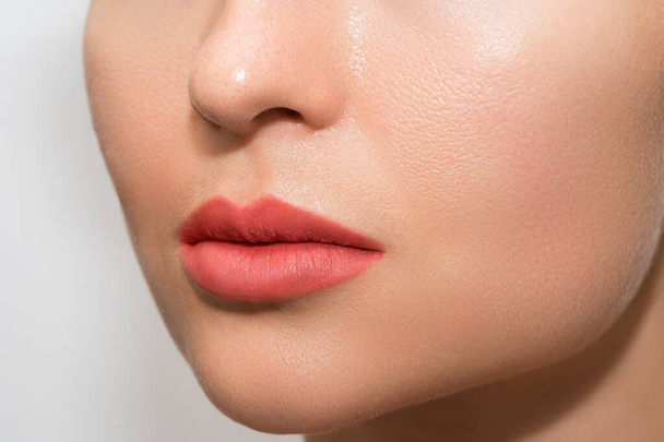 Closeup of female lips after permanent makeup lip blushing procedure - Фото, зображення
