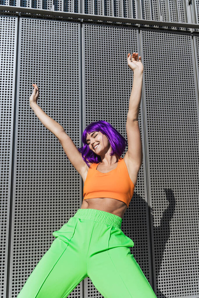 Carefree active woman dancer wearing colorful sportswear having fun on the street during summer sunny day - Φωτογραφία, εικόνα