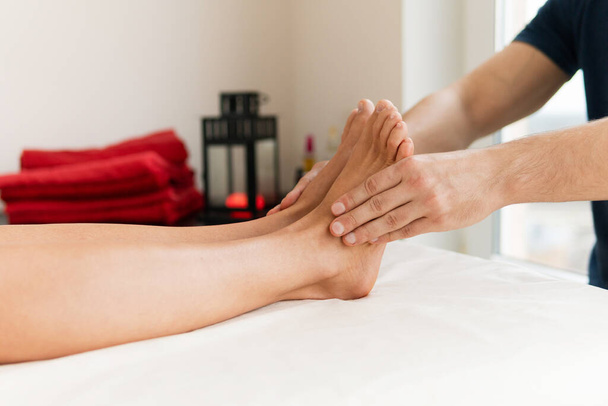 Masseur man during integrative medicine treatment - female foot massage - Valokuva, kuva
