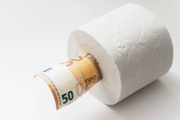 Zbliżenie banknotu 50 euro umieszczonego w rolce papieru toaletowego. Koncepcja niedoboru podstawowych składników podczas pandemii kovid-19. - Zdjęcie, obraz
