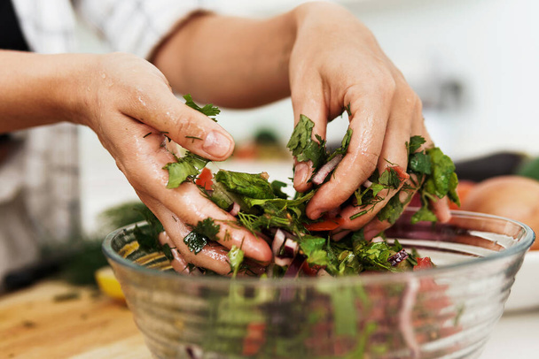 Closeup of female hands mixing vegetarian salad in the bowl - Photo, Image