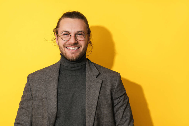 Portrait of handsome bearded man wearing  glasses smiling on  yellow background - Φωτογραφία, εικόνα