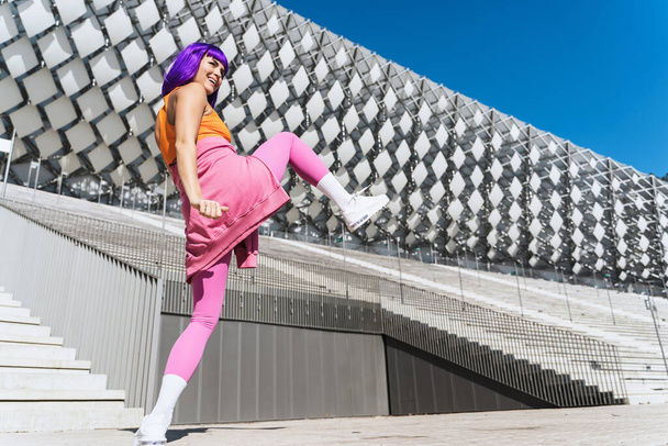 Carefree active woman dancer wearing colorful sportswear having fun on the street during sunny day - 写真・画像