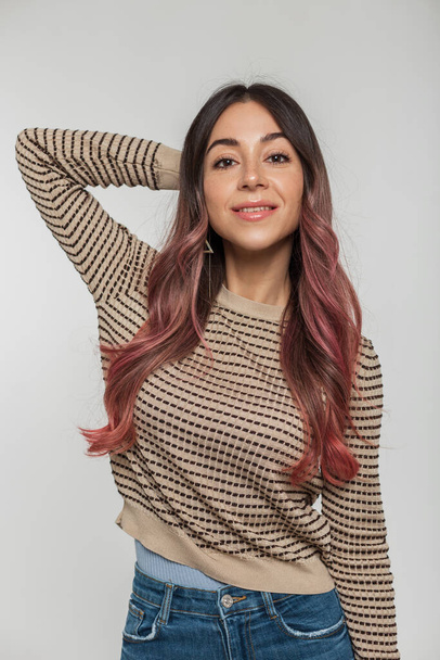 Studio muotokuva kaunis nuori tyttö hymyillen vaaleanpunaiset hiukset trendikäs villapaita valkoisella taustalla - Valokuva, kuva