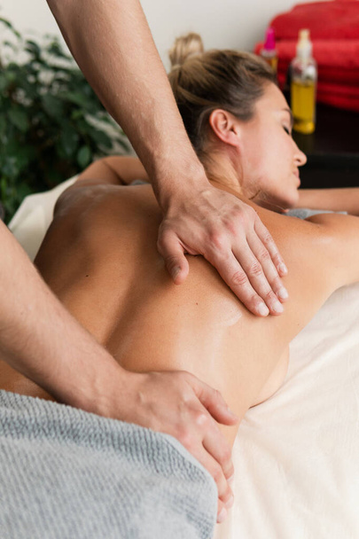 Masseur man doing back massage for his client in professional massage clinic - 写真・画像