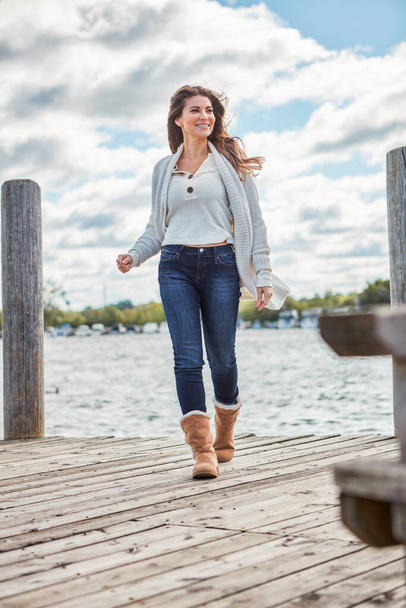 Hová mész, hogy elengedd? egy gyönyörű fiatal nő sétál a mólón a tónál. - Fotó, kép