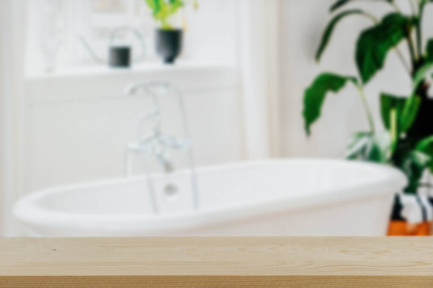 Focus sélectif sur table en bois vide contre le fond de salle de bain clair et flou. Comptoir et espace de copie pour les produits de routine quotidiens et de beauté dans l'intérieur moderne. Affichage minimaliste des produits - Photo, image